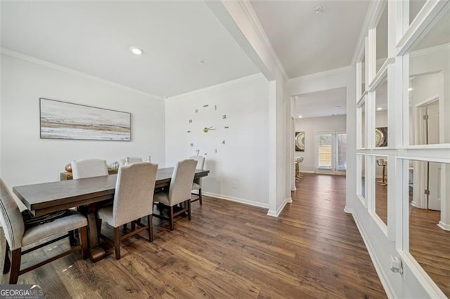 dining space with ornamental molding, wood finished floors, and baseboards