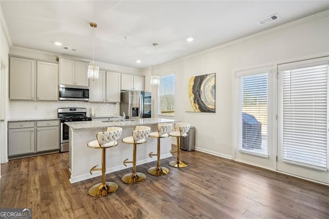 kitchen featuring stainless steel appliances, a healthy amount of sunlight, decorative backsplash, and crown molding