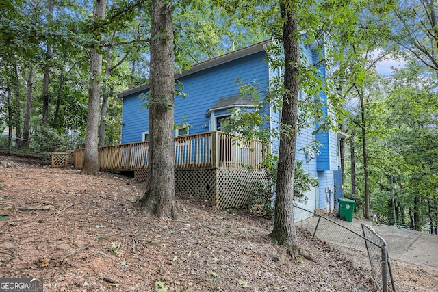 back of house with fence and a wooden deck