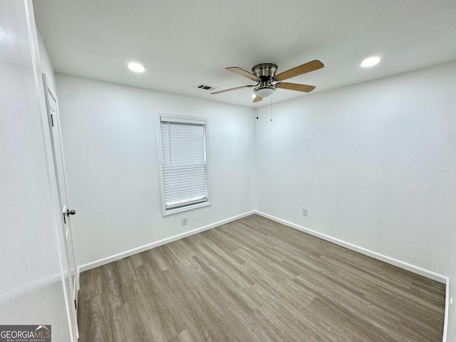 spare room with recessed lighting, wood finished floors, visible vents, and baseboards