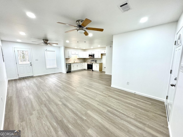 unfurnished living room with recessed lighting, baseboards, ceiling fan, and light wood finished floors