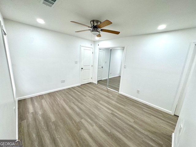 unfurnished bedroom featuring recessed lighting, wood finished floors, visible vents, and baseboards