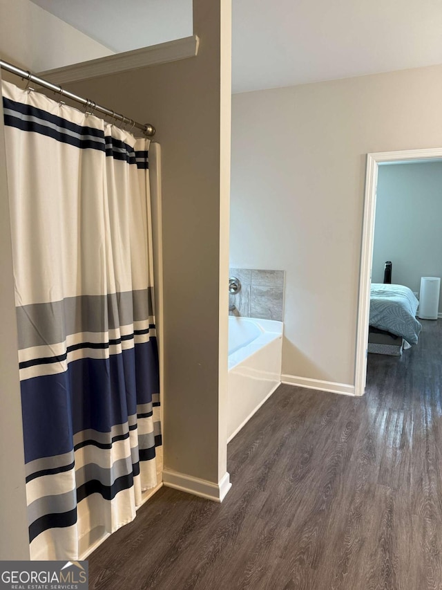 full bathroom with a garden tub, baseboards, curtained shower, and wood finished floors