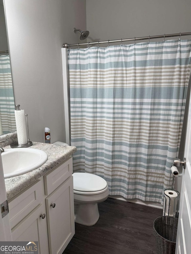 full bathroom with a shower with curtain, vanity, toilet, and wood finished floors