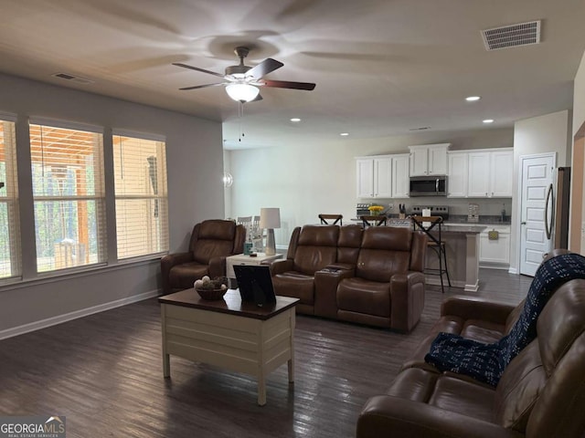 living area with dark wood-style floors, recessed lighting, visible vents, and baseboards