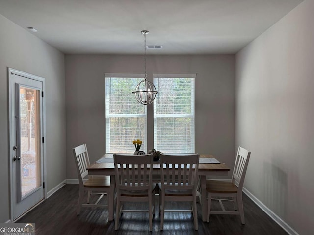 dining area featuring a chandelier, wood finished floors, visible vents, and baseboards