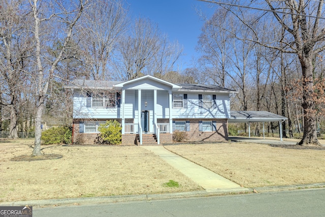 split foyer home featuring a carport, brick siding, and a front lawn