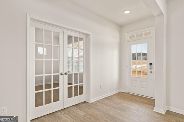 doorway with french doors, a healthy amount of sunlight, baseboards, and wood finished floors