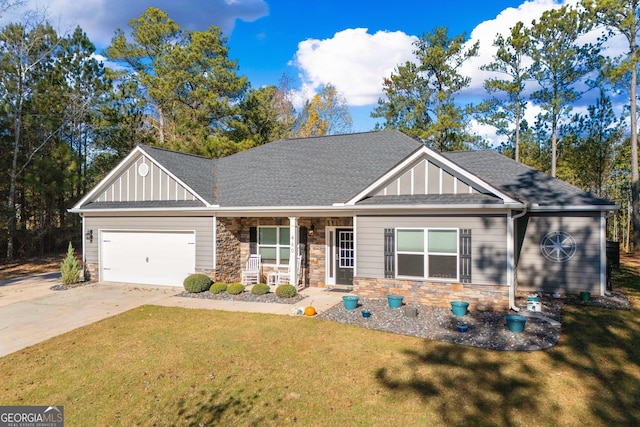 craftsman-style house with a garage, stone siding, a front yard, and driveway