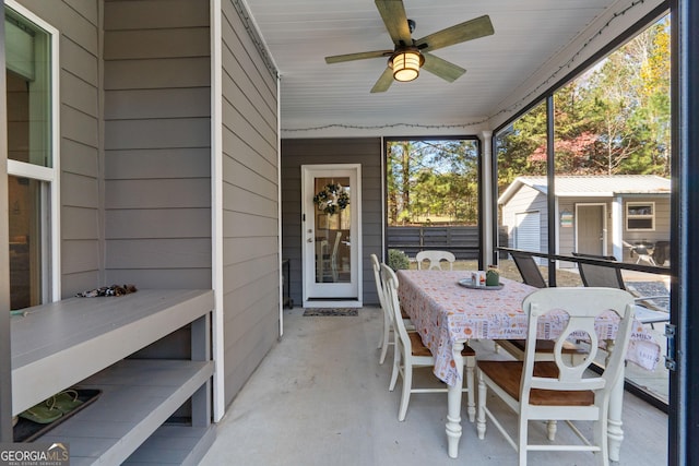 unfurnished sunroom with ceiling fan