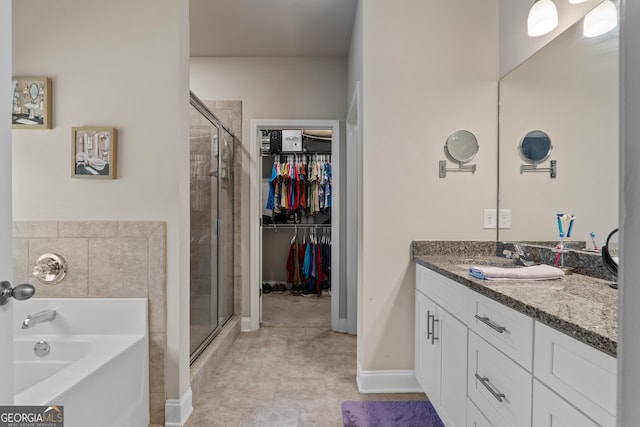 full bathroom featuring a stall shower, a garden tub, a spacious closet, and vanity