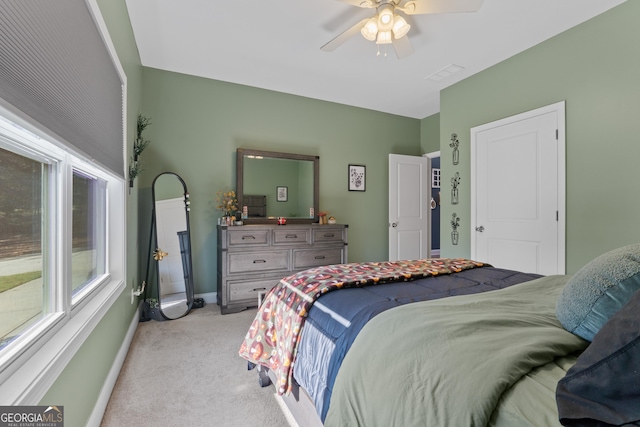 bedroom featuring light carpet, ceiling fan, visible vents, and baseboards