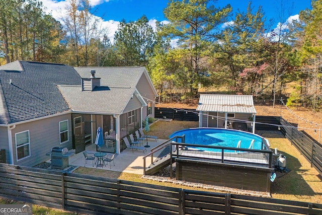 view of pool with an outbuilding, a patio area, a fenced backyard, and a fenced in pool