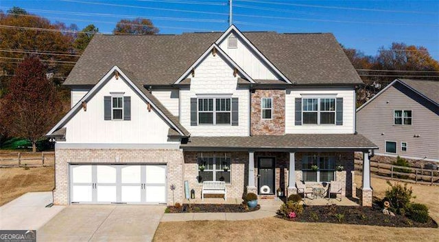 view of front of property with driveway, an attached garage, fence, a porch, and brick siding