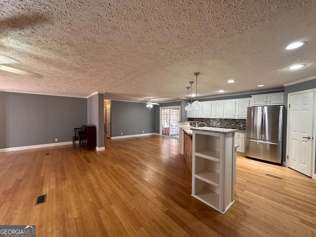 kitchen with a ceiling fan, open floor plan, freestanding refrigerator, open shelves, and light wood finished floors