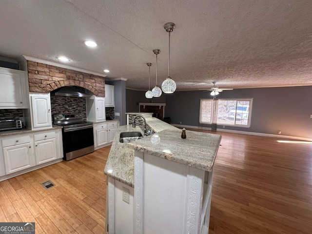 kitchen featuring light wood finished floors, stainless steel electric range oven, ornamental molding, a sink, and backsplash