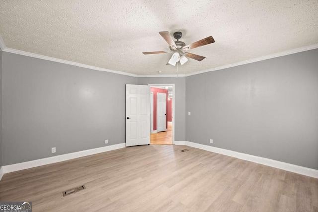 spare room featuring crown molding and light wood finished floors