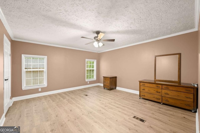 unfurnished bedroom featuring crown molding, visible vents, a textured ceiling, wood finished floors, and baseboards