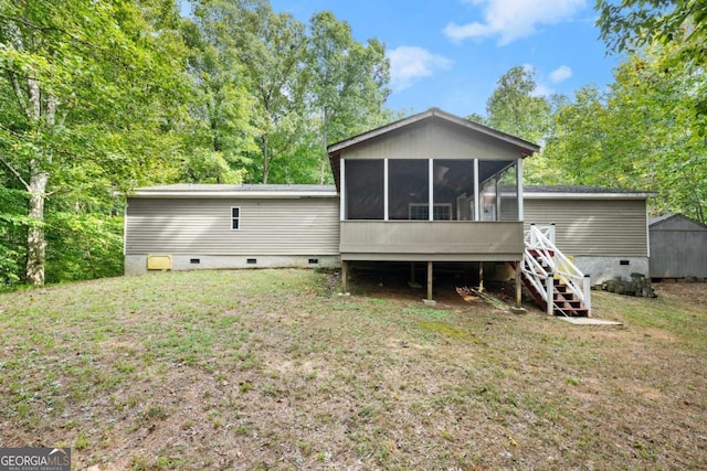 rear view of house with crawl space, a sunroom, stairway, and a yard