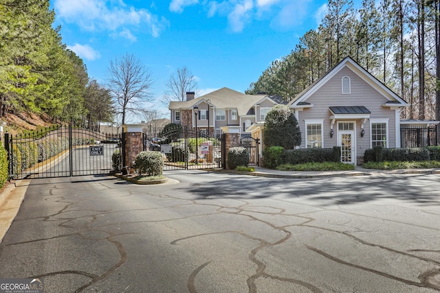 view of road featuring a gate, curbs, and a gated entry