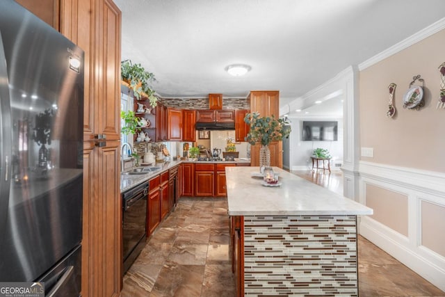 kitchen featuring black dishwasher, a decorative wall, ornamental molding, freestanding refrigerator, and a sink