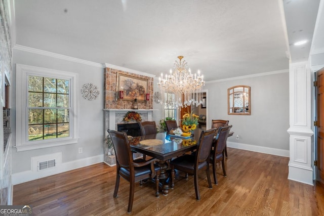 dining area featuring baseboards, wood finished floors, visible vents, and crown molding