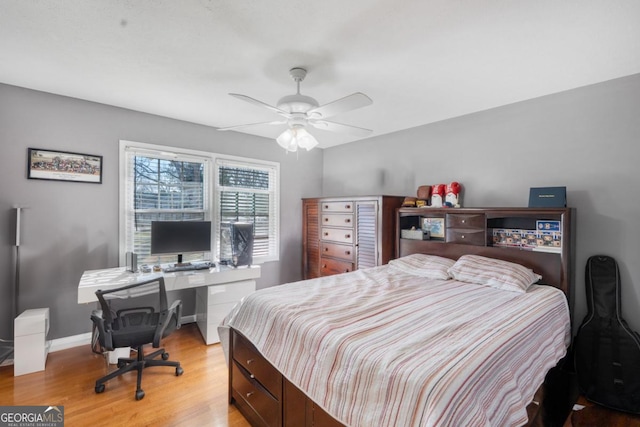 bedroom featuring a ceiling fan, light wood-style flooring, and baseboards