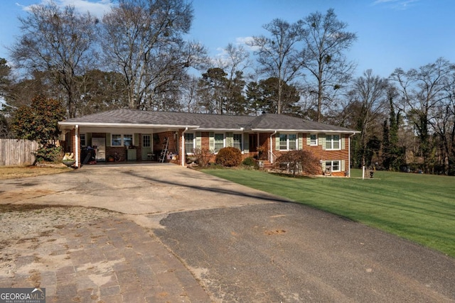 ranch-style home featuring driveway, an attached carport, fence, a front lawn, and brick siding