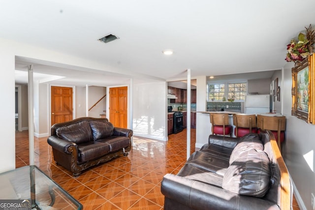 tiled living room with stairway and baseboards