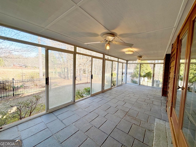 unfurnished sunroom featuring a ceiling fan