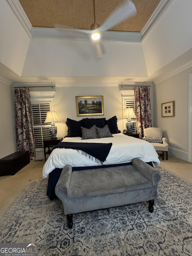 bedroom with carpet floors, ceiling fan, ornamental molding, and a raised ceiling