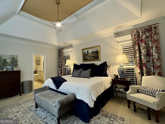 bedroom with a tray ceiling, ensuite bathroom, ornamental molding, a ceiling fan, and light carpet