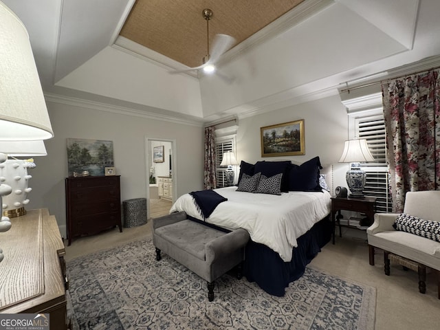 bedroom featuring ornamental molding, carpet flooring, a raised ceiling, and connected bathroom