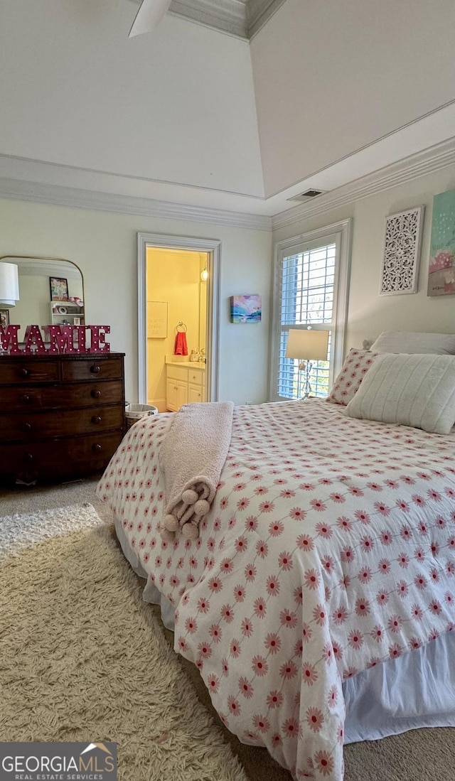 carpeted bedroom featuring vaulted ceiling, visible vents, crown molding, and ensuite bath