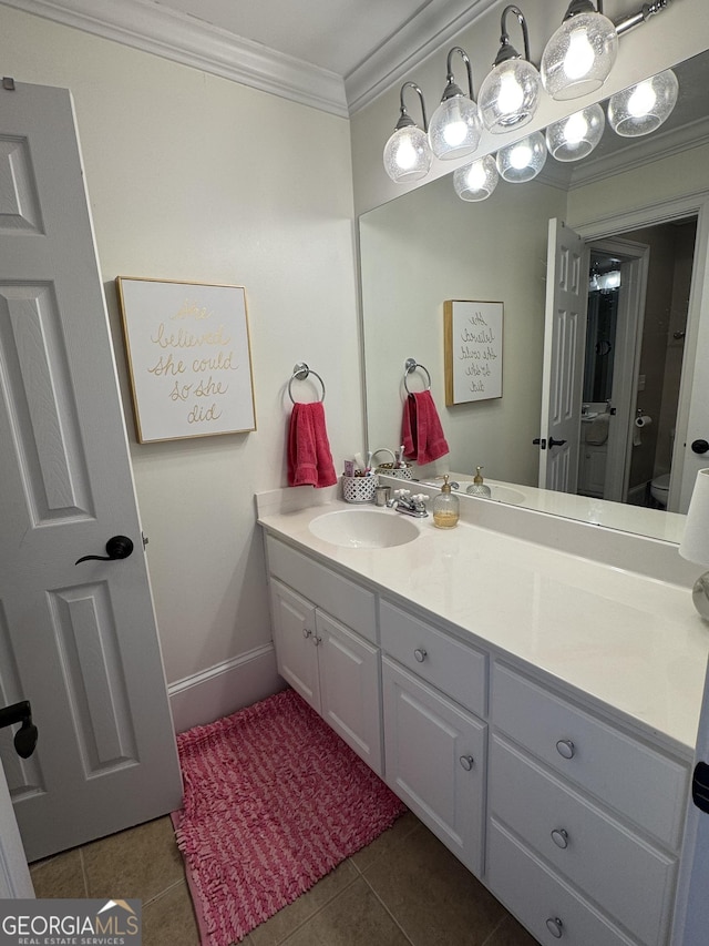 bathroom with toilet, tile patterned flooring, crown molding, and vanity