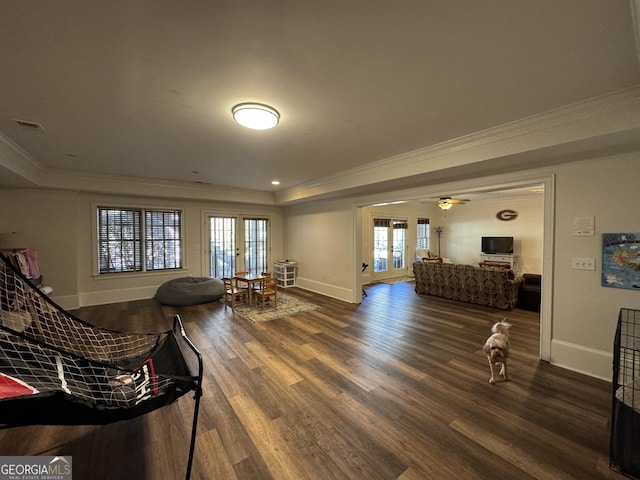 living area with baseboards, ceiling fan, wood finished floors, crown molding, and french doors