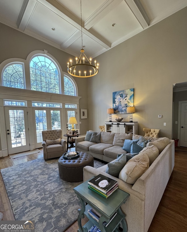 living room featuring plenty of natural light, wood finished floors, and a towering ceiling