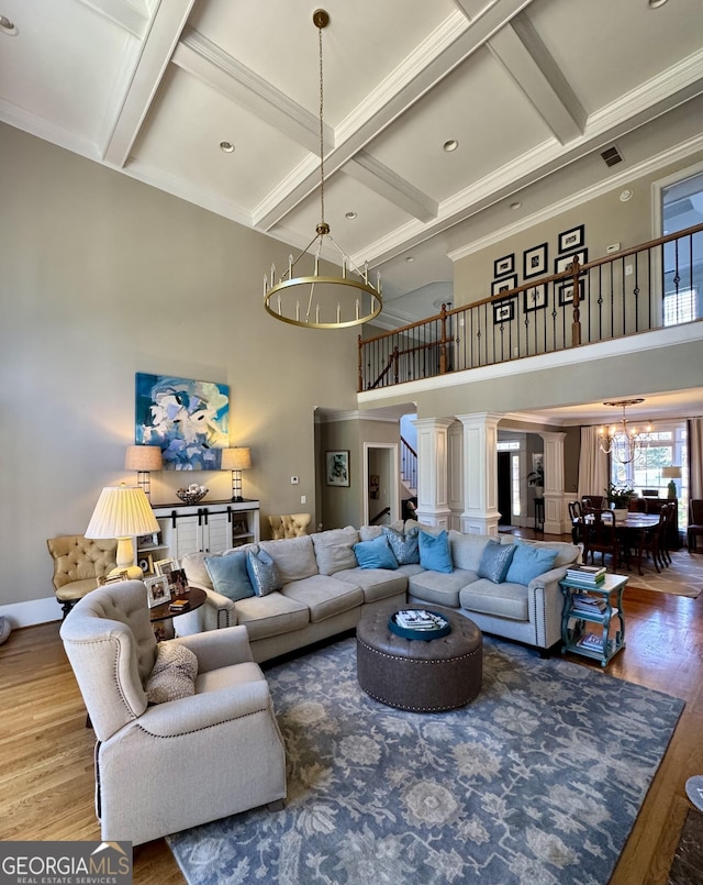 living room featuring stairway, a high ceiling, ornamental molding, wood finished floors, and coffered ceiling