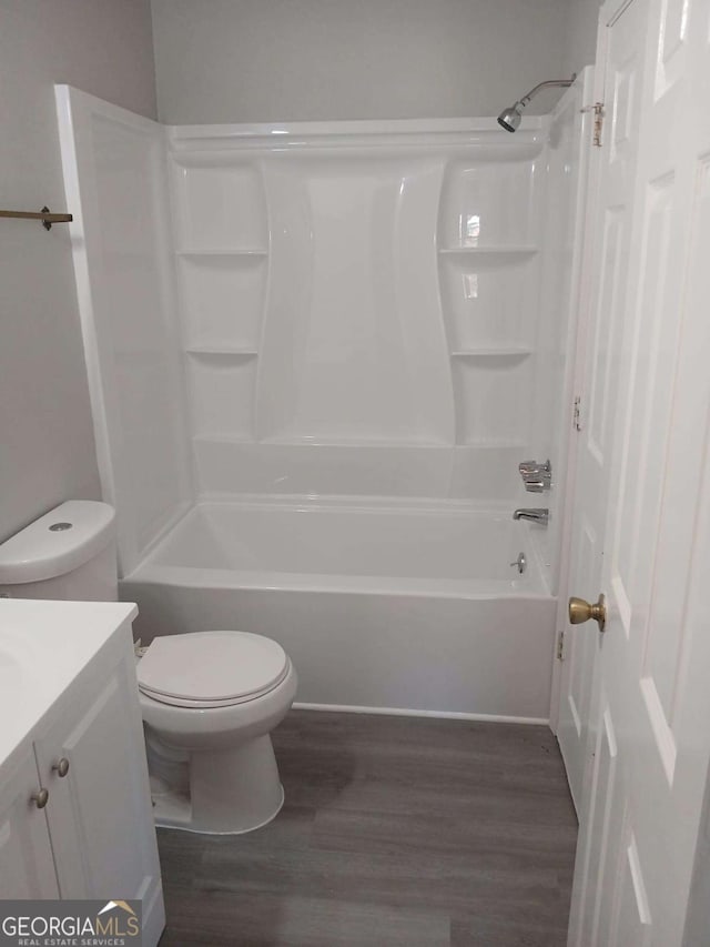 bathroom featuring shower / washtub combination, vanity, toilet, and wood finished floors