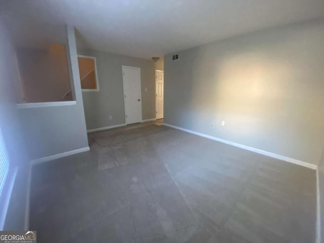 unfurnished room with visible vents and baseboards