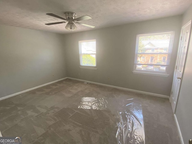 carpeted spare room with a ceiling fan, a textured ceiling, and baseboards