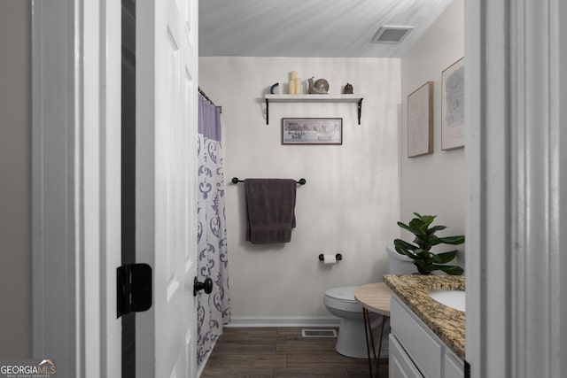 full bathroom with visible vents, vanity, toilet, and wood finished floors