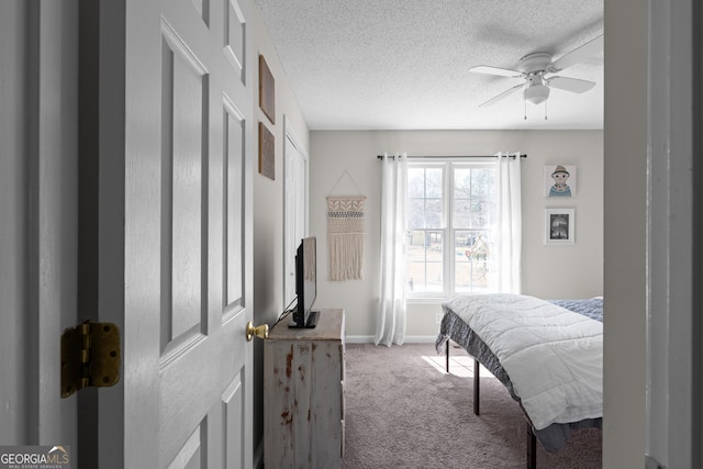 bedroom with carpet floors, a ceiling fan, baseboards, and a textured ceiling