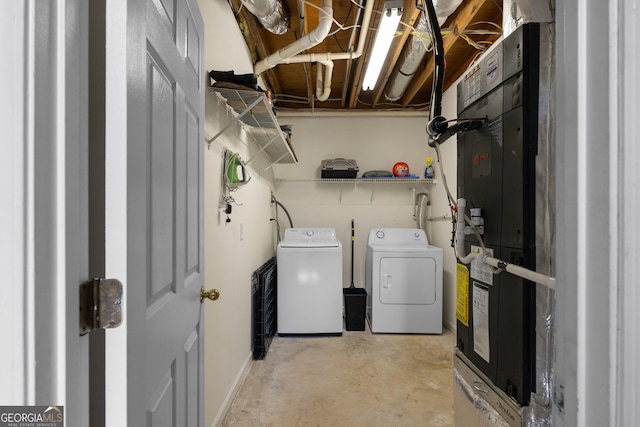 clothes washing area featuring laundry area, independent washer and dryer, and heating unit