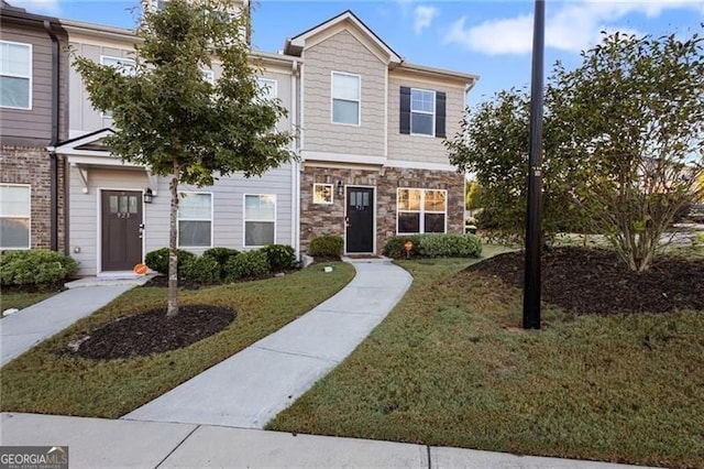 view of front of home with stone siding and a front lawn