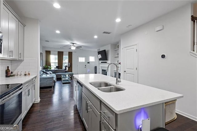 kitchen with dark wood-style floors, stainless steel appliances, gray cabinets, visible vents, and a sink