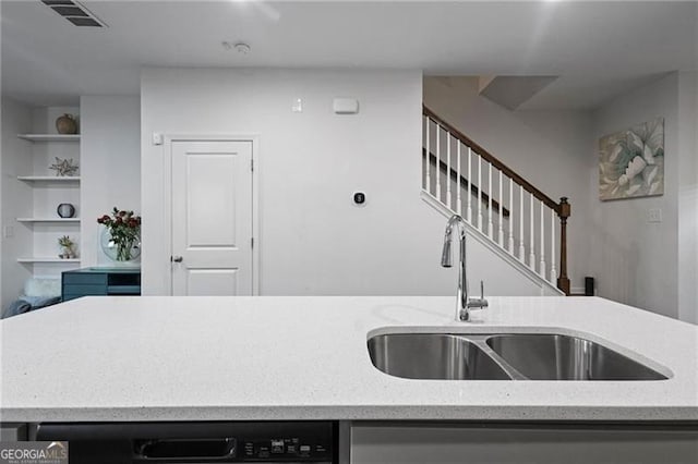 kitchen featuring visible vents, a sink, dishwashing machine, and light stone countertops