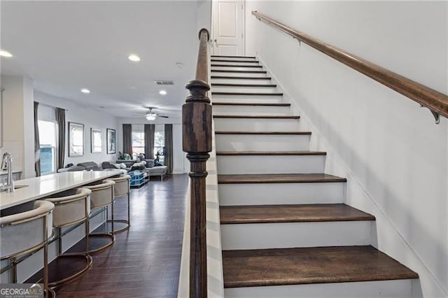 stairs featuring ceiling fan, visible vents, wood finished floors, and recessed lighting