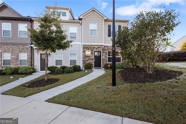 multi unit property featuring stone siding and a front lawn