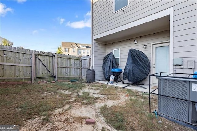 view of yard featuring central air condition unit, a patio area, a gate, and fence